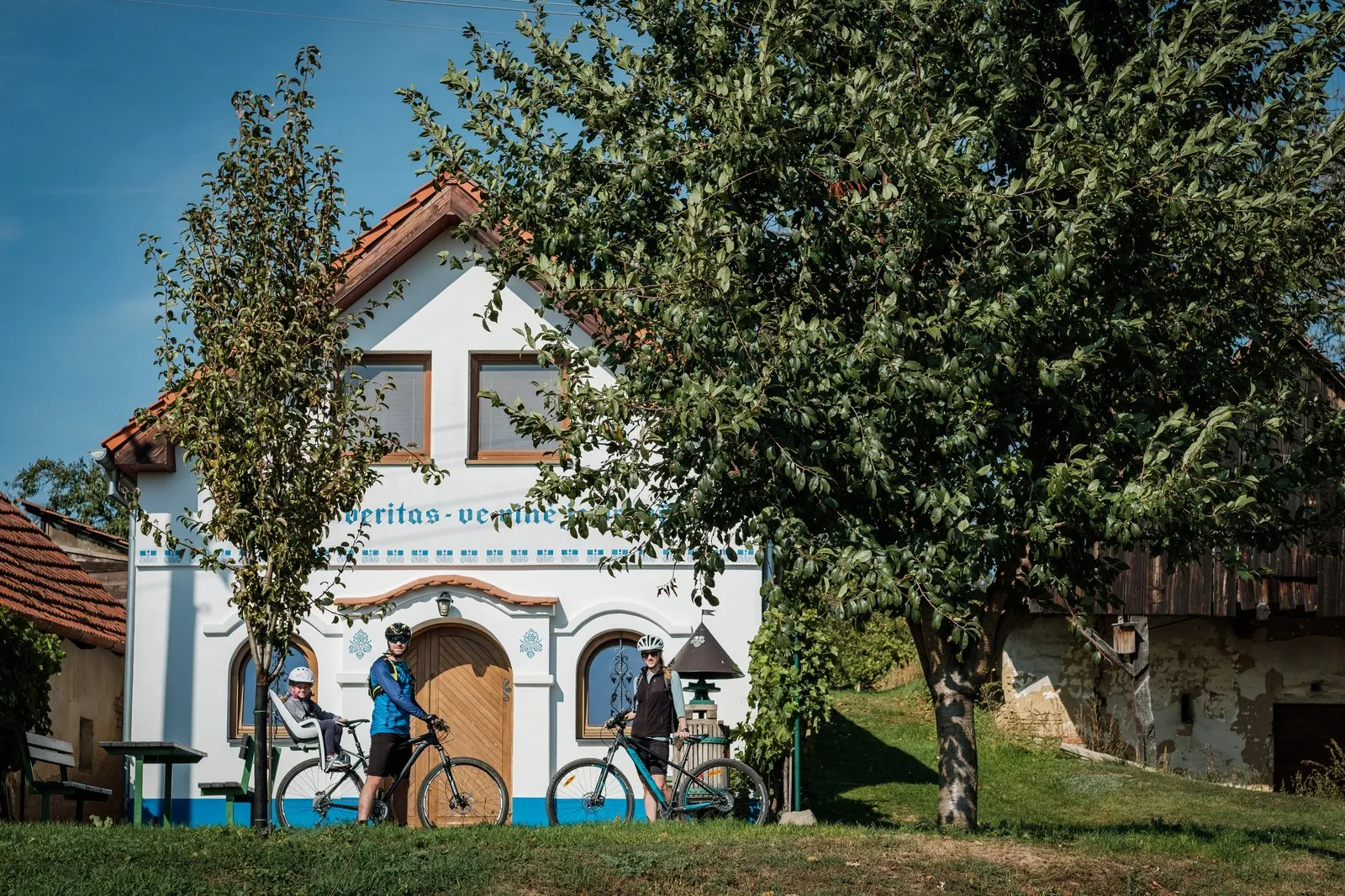 Cyklité před tradičním slováckým domem