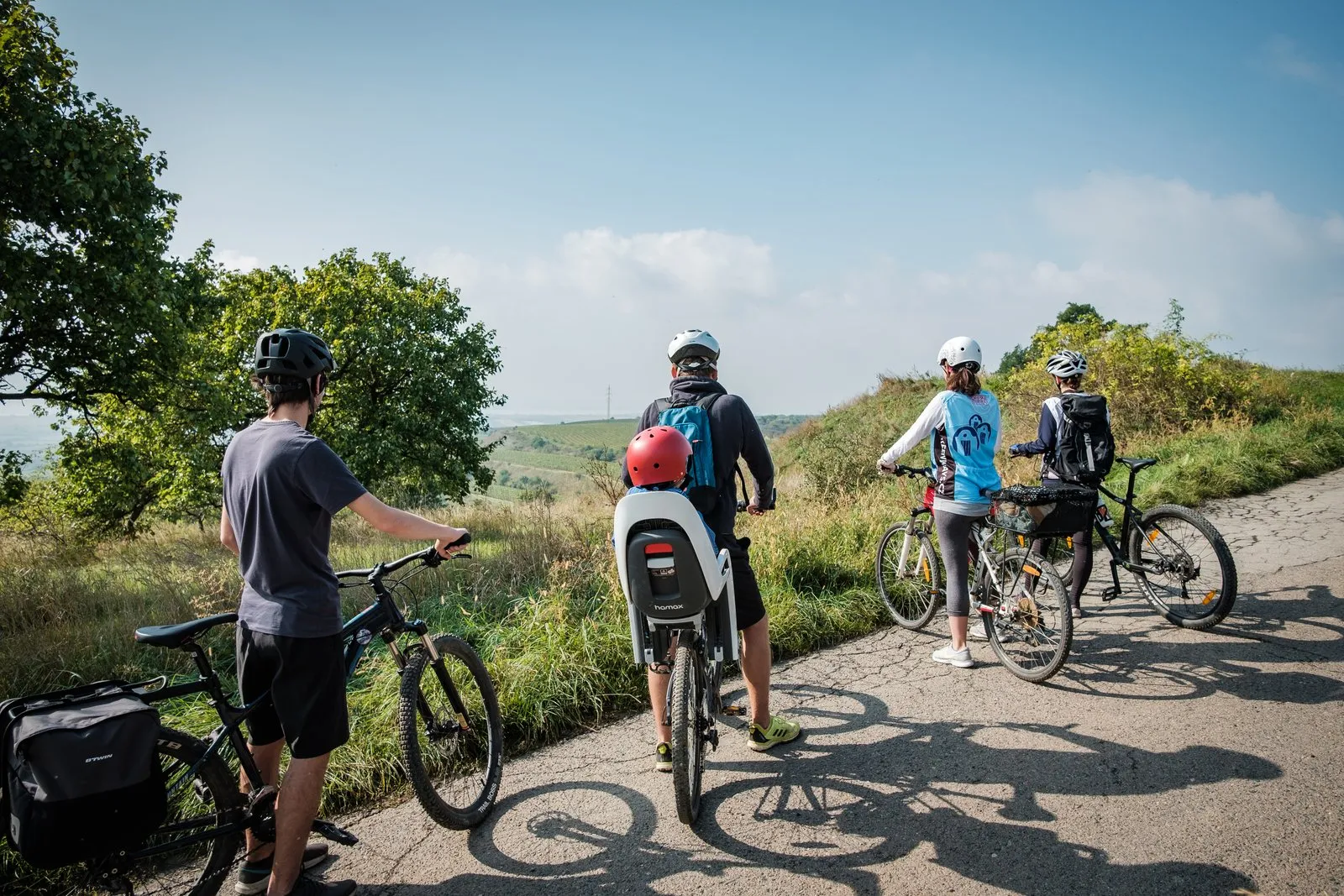 Rodinka cyklistů se kochá výhledem do krajiny